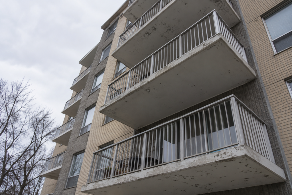 Weathered painted balcony railings and soffits on an Ottawa condo